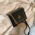 Alt text: Bolsa tiracolo feminina de couro estruturada preta elegante.