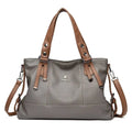 Alt text: Bolsa feminina de mão em couro genuíno marrom elegante.