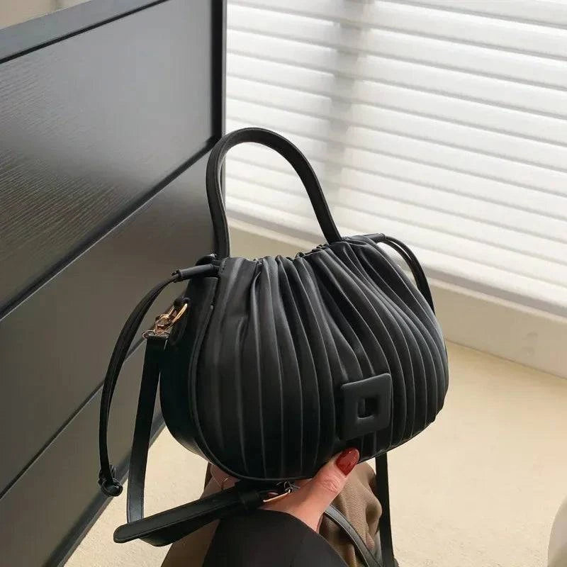 Alt text: Bolsa feminina bucket texturizada em tom neutro elegante.