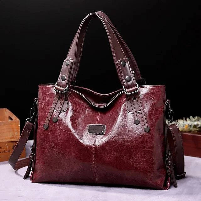 "Bolsa feminina de ombro clássica em couro envernizado preto."
