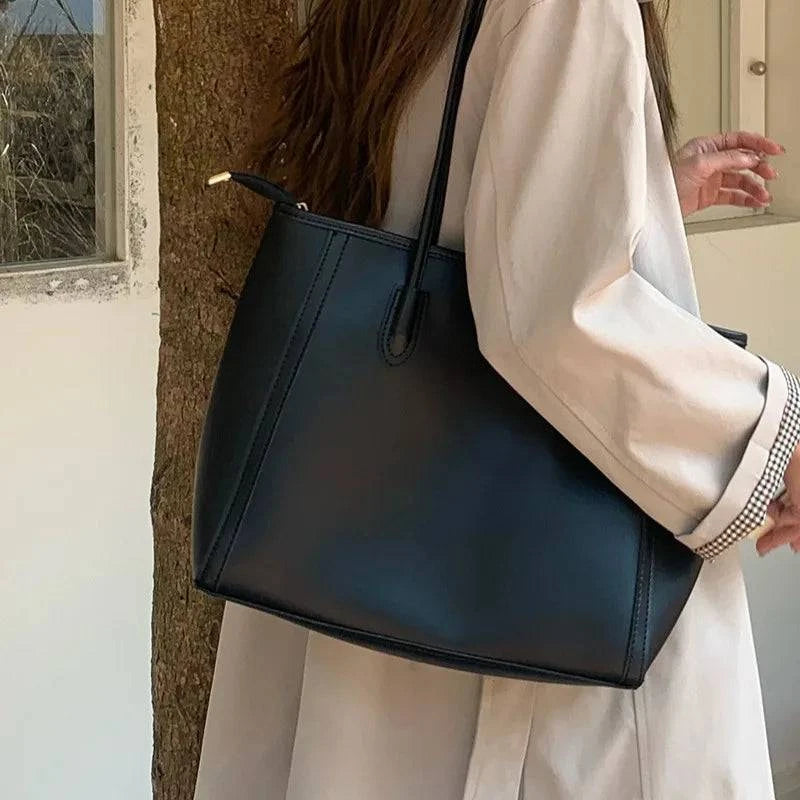 Alt text: Bolsa feminina de couro preta estilo tote glam elegante.