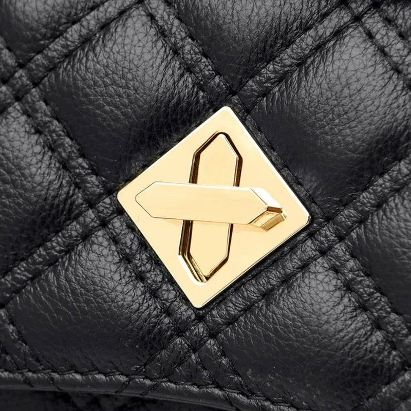 Alt text: Bolsa tiracolo acolchoada preta com corrente de metal.