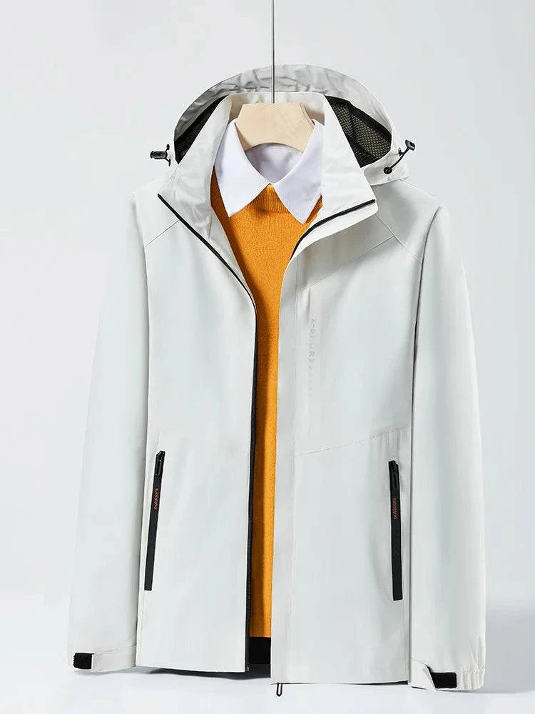 Jaqueta corta-vento branca com capuz embutido, aberta revelando uma camisa social branca e um suéter laranja por baixo. Peça versátil e elegante para um estilo de sobreposição sofisticado.