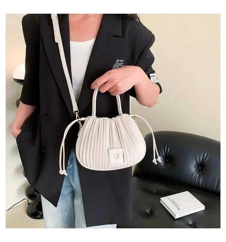 Alt text: Bolsa feminina bucket texturizada em tom neutro elegante.