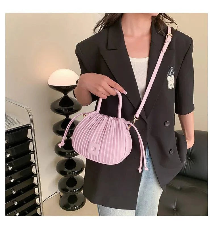 Alt text: Bolsa feminina bucket texturizada em tom neutro elegante.