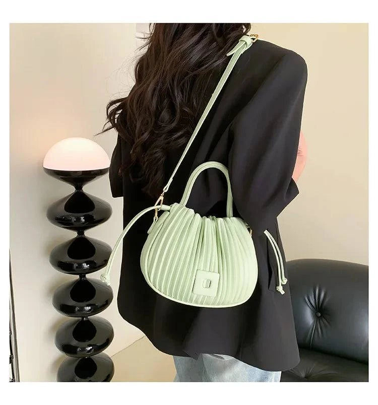 Alt text: Bolsa feminina bucket texturizada em tom neutro elegante.