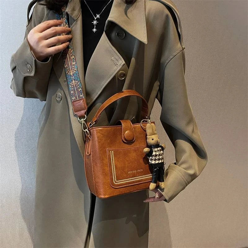Alt text: Bolsa Tote Feminina Transversal Pequena Cristalle em tom neutro.