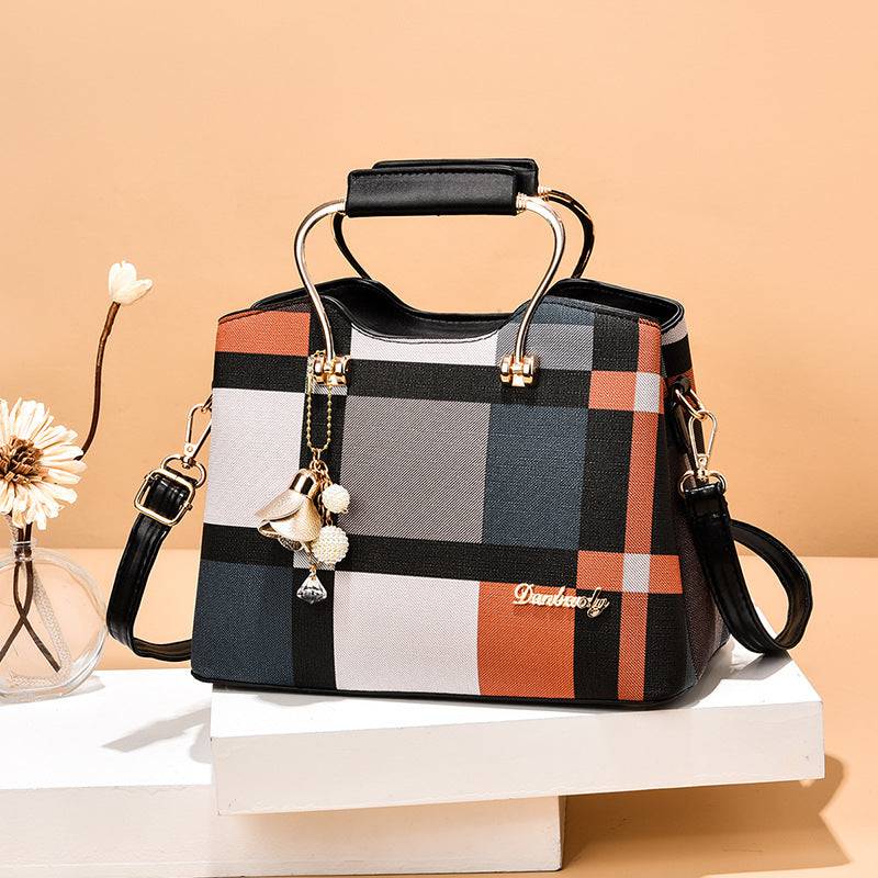 Alt text: Bolsa feminina de couro estruturada com estampa xadrez em tons neutros.