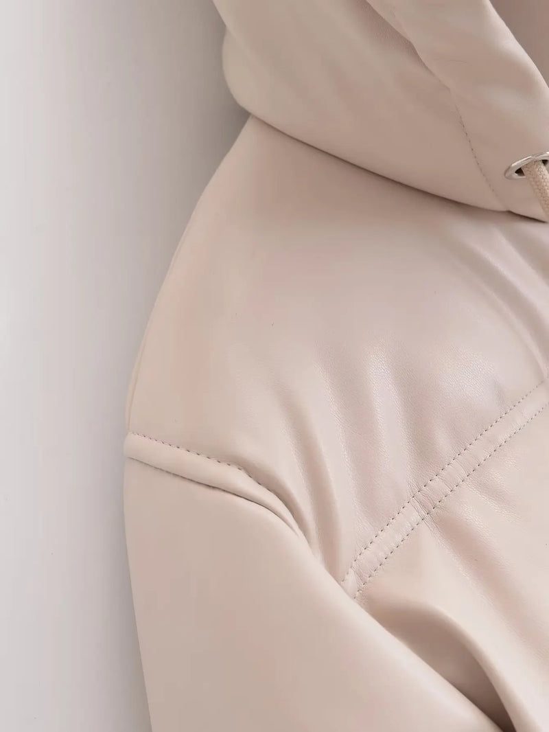 Close-up de uma Jaqueta Puffer Feminina para Inverno bege claro da Zellum em couro sintético, mostrando a superfície lisa e levemente brilhante e a costura detalhada no ombro e no braço - ideal para uso no inverno.