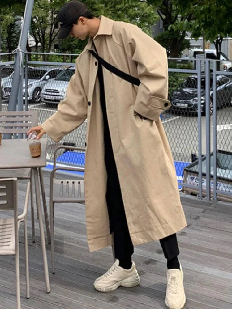 Look casual com sobretudo masculino creme, calça preta e tênis branco. Ideal para moda masculina outono/inverno com estilo europeu.