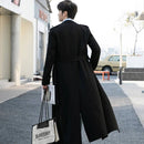 Homem de costas usando trench coat preto longo em ambiente urbano