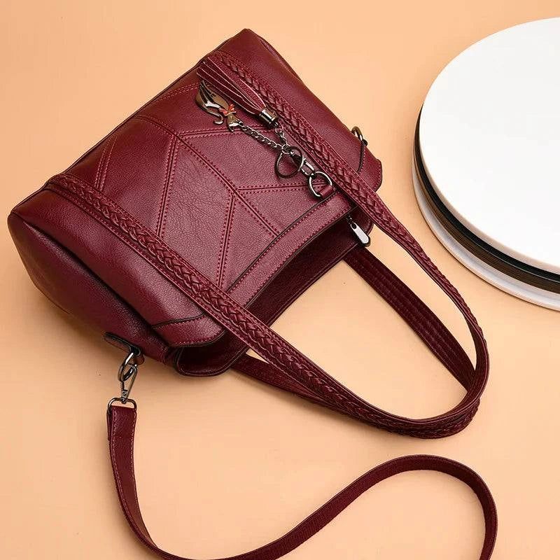 Bolsa Tote preta em couro sintético com alça adicional.