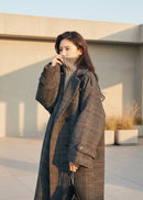 Mulher em sobretudo xadrez cinza com gola alta e corte oversized