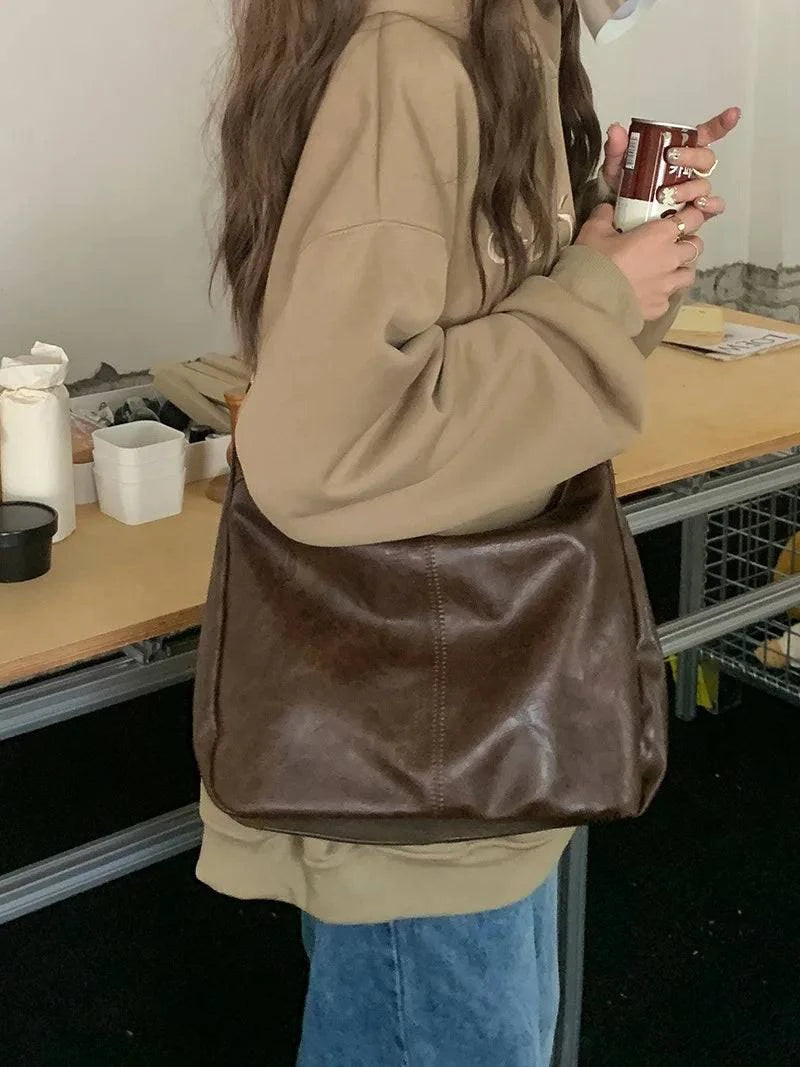Alt text: Bolsa feminina de couro hobo marrom elegante e espaçosa.