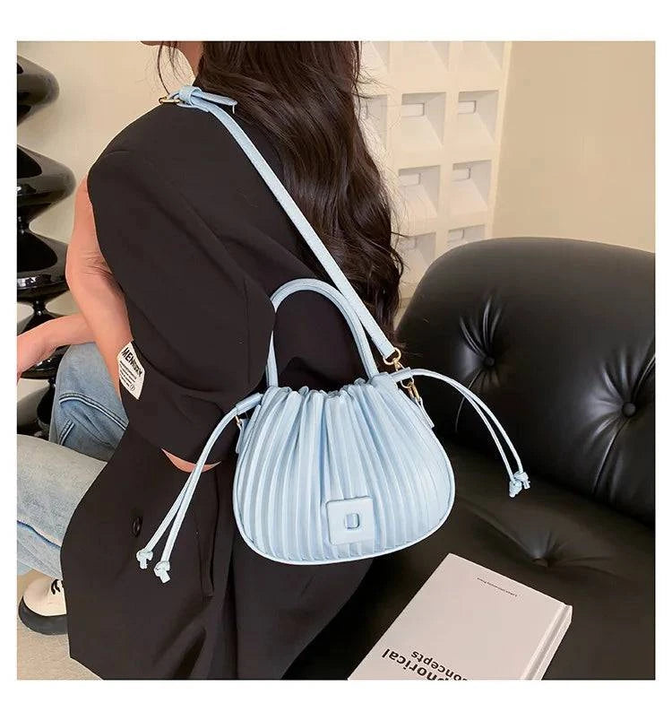 Alt text: Bolsa feminina bucket texturizada em tom neutro elegante.