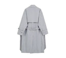 Costas de trench coat cinza com cinto, modelagem solta e pregas traseiras.