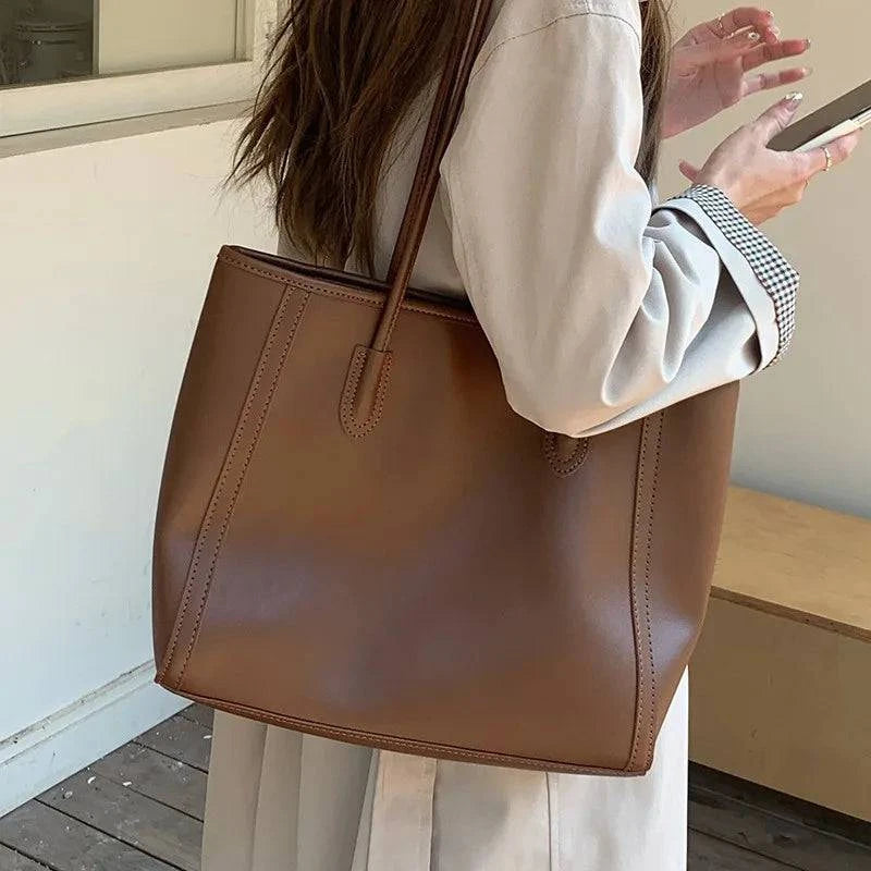 Alt text: Bolsa feminina de couro tote glam preta elegante e sofisticada.