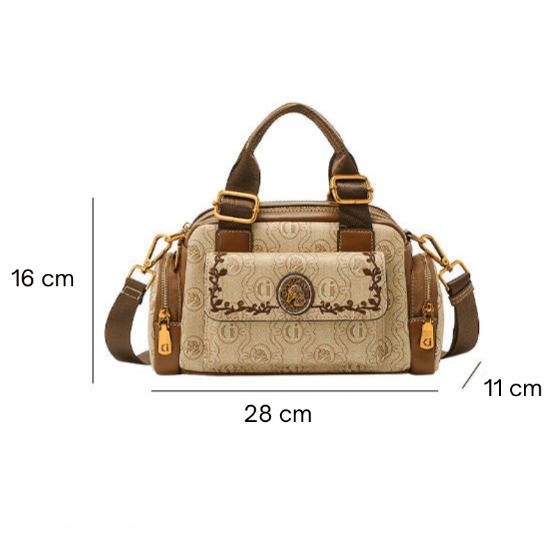 Alt text: Bolsa baú feminina preta em couro com alça ajustável.