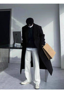 Sobretudo Coreano Masculino Longo preto em visual moderno com calça branca e tênis. Ideal para composições casuais e elegantes no inverno.