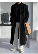 Sobretudo Coreano Masculino Longo preto com corte reto, usado com tênis branco e calça clara. Perfeito para estilo casual urbano com toque coreano.