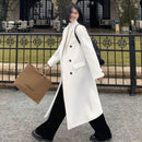 Mulher usando sobretudo longo off-white com abotoadura dupla e calça preta