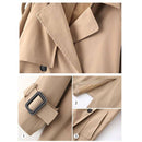 Trench coat feminino bege com detalhe de fivela decorativa nos abotoamentos