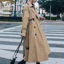 Mulher com trench coat bege botões duplos em praça urbana