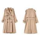 Trench coat feminino bege com dupla fileira de botões, cinto e pregas