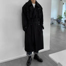 Trench coat preto masculino até os joelhos com cinto, sobre camiseta branca e jeans