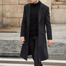Sobretudo preto de lã sobre gola alta e calça preta, look urbano minimalista.