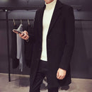 Homem vestindo sobretudo slim preto com gola de turtleneck branco, segurando amostra de tecido cinza