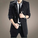 Homem com trench coat preto duplo-travado, camisa listrada e cinto
