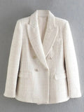 Blazer alfaiataria feminino branco texturizado pendurado contra parede cinza