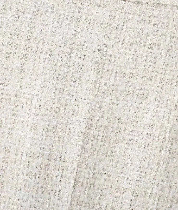 Close do tecido do blazer feminino bege, textura encorpada com leve brilho sofisticado.
