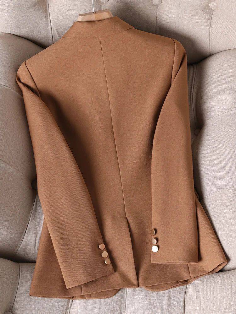 Costas do blazer feminino alfaiataria caramelo com detalhes de botões nas mangas.