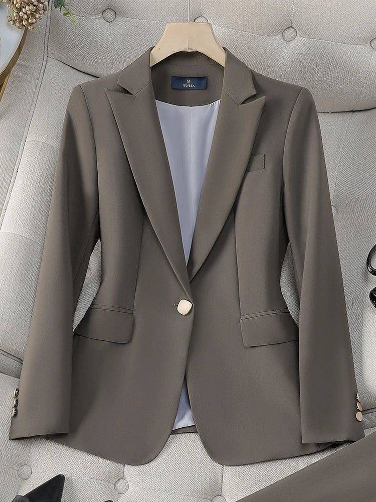 Blazer feminino alfaiataria verde oliva com botão único, sobre sofá claro