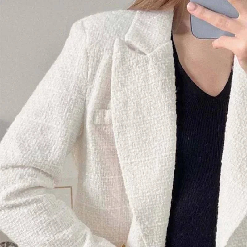 Blazer feminino branco de alfaiataria com mangas.