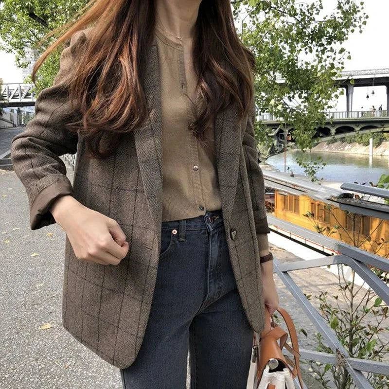 Estilo casual com blazer xadrez marrom e calça jeans preta próximo ao rio