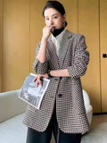 Blazer feminino oversized pied-de-poule preto e branco em pose sofisticada