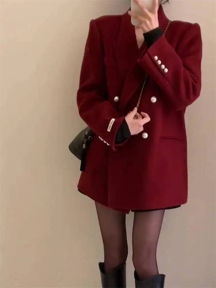 Blazer feminino oversized vermelho vinho com mão na cintura e bolsa preta