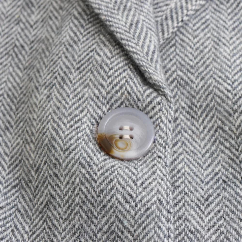 Detalhe do botão frontal do blazer feminino cinza de alfaiataria