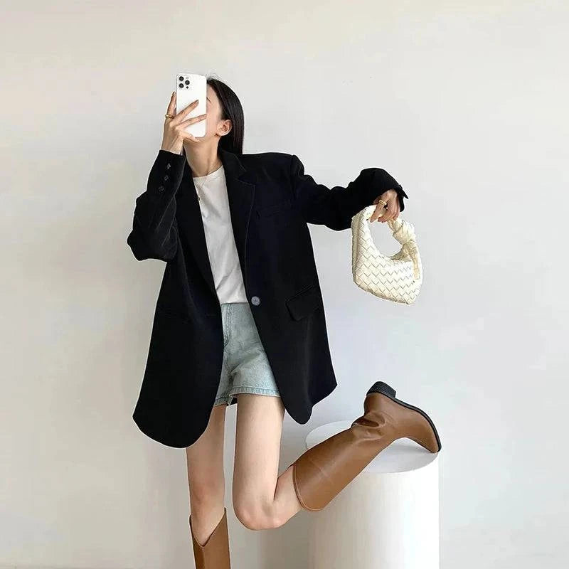 Blazer social feminino preto oversized usado com bota marrom e bolsa branca