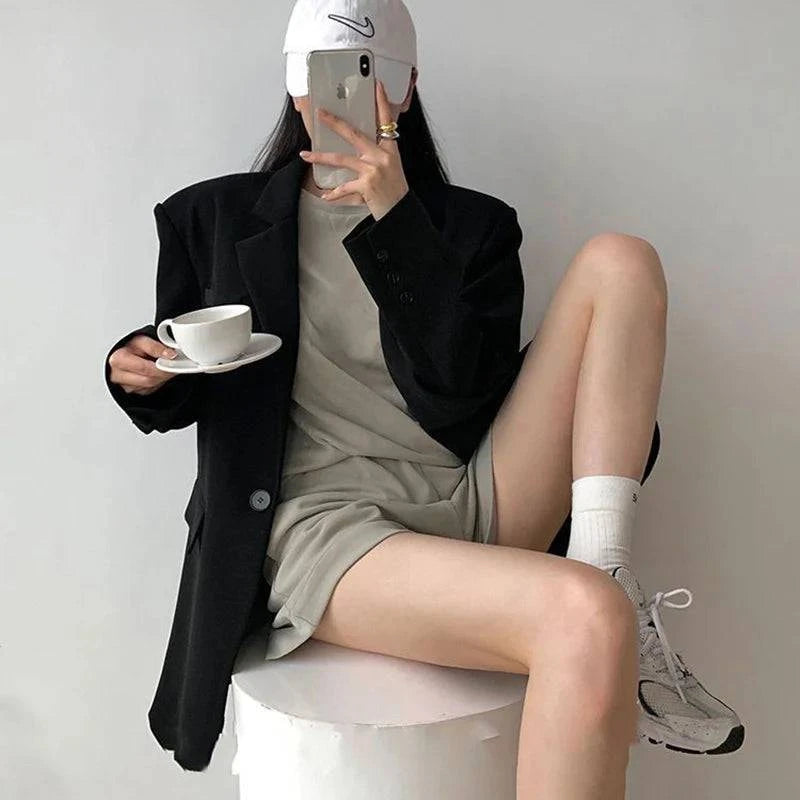 Blazer social feminino preto em look esportivo com boné e tênis branco