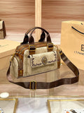 Bolsa Baú Feminina marrom e bege, tecido estampado. Bolso frontal bordado com leão dourado, zíperes laterais. Alça transversal ajustável. Elegante e estruturada.