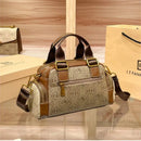 Bolsa baú feminina bege com padrão monogramado, alças marrom e alça transversal ajustável