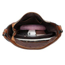 Bolsa de couro marrom Suzy aberta mostrando interior com carteira rosa, carregador portátil e organizador de bolsa