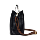 Perfil lateral da bolsa feminina de couro Violet preta, com alça transversal marrom estendida, exibindo sua forma elegante e detalhes em metal prateado na alça superior.