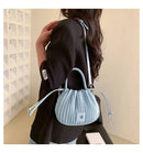 Bolsa bucket texturizada azul-claro com pregas, alças ajustáveis e fechamento com cordão