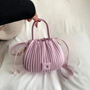 Bolsa bucket texturizada lilás com pregas verticais, alças e tira transversal