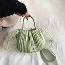 Bolsa bucket texturizada verde-claro com alça e correia transversal ajustável
